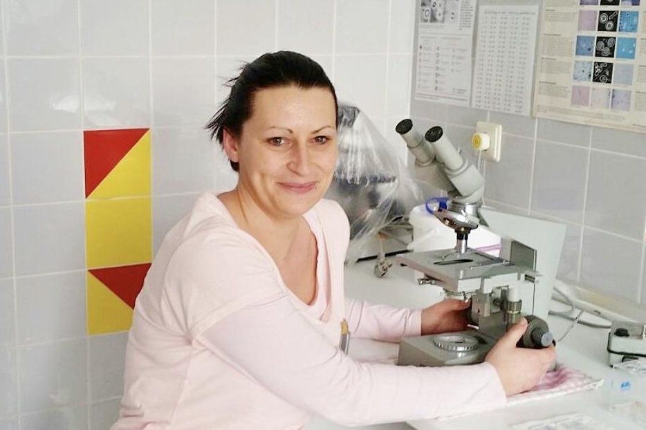 Claudia, Arzthelferin, am Mikroskop im Praxislabor